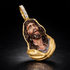 Gold pendant with a detailed face design on a dark background